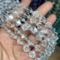 Macro shot of clear faceted crystal bicone beads showing precise diamond-cut geometry - Clear Quartz 1 Strand