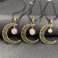 Macro detail of bronze hollow moon pendants with raw rose quartz stones on black surface - Rose Quartz 1pc