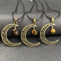 Detailed close-up of bronze moon pendants with tiger eye stones and hollow carvings - Tiger Eye 1pc