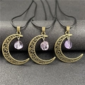 Detailed view of bronze hollow moon pendants with raw purple amethyst on black cords - Amethyst 1pc