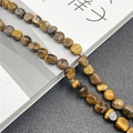 Detailed view of polished tiger eye flat round beads with natural golden brown stripes - Tiger's Eye