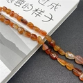 Close-up of irregular natural red agate stone beads showing translucency and texture - Red Agate