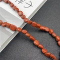 Polished red jasper irregular nuggets strung together showing natural stone texture - Rainbow Stone
