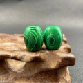 Pair of green malachite barrel beads with natural stripes on a rustic wood stand - 1 Piece / Malachite (Synthetic)