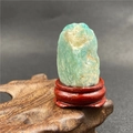 Pierre minérale d'amazonite naturelle sur un socle en bois rouge à texture brute - Amazonite