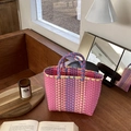 Detail of multi-color handwoven basket bag with plaid pattern on a wooden table - Pink Color Blocking