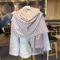 Pink and black checkered scarf with fringe worn over a beige wool winter coat - Pink