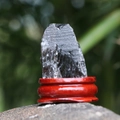 Pietra di ossidiana naturale grezza con trama vetrosa su base in legno rosso - Quarzo fumé