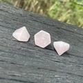 Three pieces of geometric rose quartz crystals with hexagonal facets on weathered wood - Rose Quartz