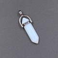 Polished hexagonal white crystal bullet pendant with silver metal clasp on dark background - Opalite