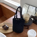 Handgefertigte schwarze geflochtene Eimertasche mit Doppelringgriffen im Café - Schwarz
