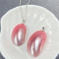 Vue détaillée d'un pendentif en nacre rose sur chaîne en argent dans un plat en céramique - 40-50mm / Rose