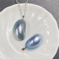 Détail macro de pendentifs en perle Mabe en forme de haricot avec éclat iridescent et chaîne - 35-45mm / Bleu