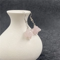 Pink crystal Merkaba star earrings with silver hooks displayed on a ceramic vase - Rose Quartz