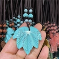 Detalle del colgante de hoja de arce de cristal azul con cordón de cuerda trenzada oscura - Turquesa Azul Sintética