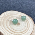 Elegante grüne runde Steinohrstecker mit Silberstiften auf einem Holzdisplay - Grüner Aventurin