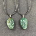 Green aventurine carved skull pendants with black braided necklace cords in a pair set - India Agate