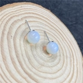 Elegante kugelförmige weiße Opal-Ohrstecker auf Holzbasis mit silbernen Stiften - Synthetischer Opal