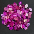 Vista macro di cabochon in agata striata ovale con trame di pietra viola e rosa - Agata a Strisce Rosa Rosso