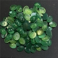 Dettaglio macro di pietre di agata verde ovali per creazione gioielli su fondo scuro - Agata verde