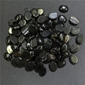 Primo piano di pietre di agata nera ovali lucide con venature bianche naturali - Agata nera