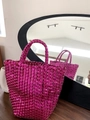 Close-up of a hot pink woven tote bag with metallic finish on a dark wooden table - Rose Red