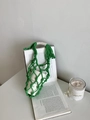 Détail d'un sac en filet vert vif tissé à la main avec poignées renforcées pour bouteilles - Vert clair