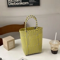 Close-up of yellow and purple woven PVC handbag with checkered pattern on a white table - Yellow & Purple