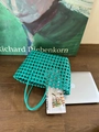 Dettaglio ravvicinato della borsa tote verde intrecciata a mano con texture in pelle intrecciata - Verde malachite