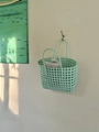 Dettaglio di una borsa a cesto intrecciata verde menta con manici tondi in un ambiente - Verde chiaro