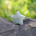 Piedra de cristal natural en forma de estrella gris claro con inclusiones verdes - Labradorita