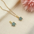 Collar de estrella dorada con colgante de piedra turquesa sobre fondo de tela blanca - Aventurina Verde