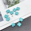 Macro detail of faceted turquoise cross beads with marble veins for DIY jewelry - Synthetic Blue Turquoise