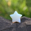 Piedra de cristal opalita pulida en forma de estrella sobre una roca natural - Ópalo Sintético