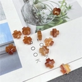 Macro detail of cross-shaped agate stone beads with DIY jewelry making accessories - Red Agate
