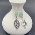Silver drop earrings featuring hollow leaf charms and a light green agate bead - Green Aventurine