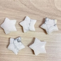 Set of five polished white howlite star-shaped natural gemstones on wooden background - White Turquoise
