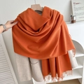 Thick bright orange cashmere-feel scarf with fringe hanging on an ivory coat - No.6 Orange