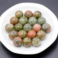 Polished 16mm natural Unakite stone spheres in a white ceramic bowl for healing - Unakite