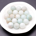 Polished natural amazonite round beads with light blue and white textures in a tray - Amazonite