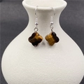 Brown tiger eye clover drop earrings with silver hooks shown on a white ceramic vase - Tiger Eye 1 Pair