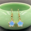 Elegant gold-plated star drop earrings with light blue opal stone on a ceramic jar - Synthetic Opal