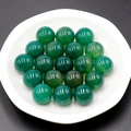 Polished 16mm natural green agate gemstone spheres displayed on a white plate - Green Agate