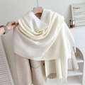 Elegant cream white fringed knit scarf draped over a beige coat on a wooden hanger - No.1 Milk White