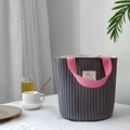 Détail du sac cylindrique matelassé gris foncé avec poignée tissée rose contrastée - Sac à main gris