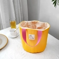 Quilted yellow canvas bucket bag with pink handles and alpaca patch in home setting - Yellow Handle
