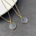 Golden necklace with circular black stone pendant featuring natural white marble texture - Synthetic Black Turquoise