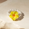 Macro view of plumeria flower beaded ring with white pearls on a stone texture background - Yellow Plumeria Style (29919-r-yel)