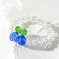 Close-up of beaded flower ring with sparkling green and blue crystals on white stone - Blue Green Berry Style (31027-ring-blue)