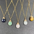 Five assorted natural crystal teardrop necklaces with gold wire wrap on dark background - Random Style